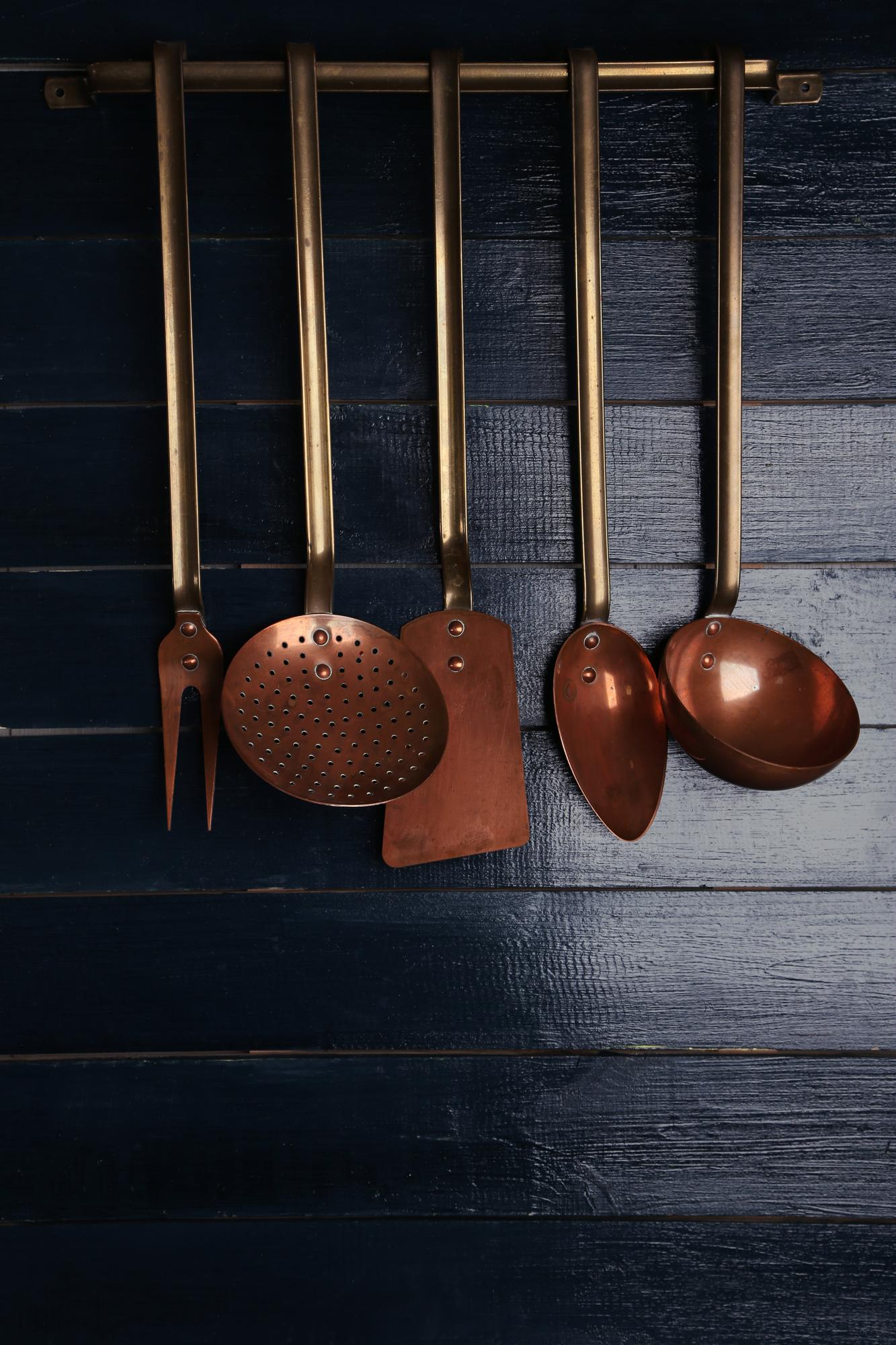 Intimate studio kitchen with brass details and culinary tools